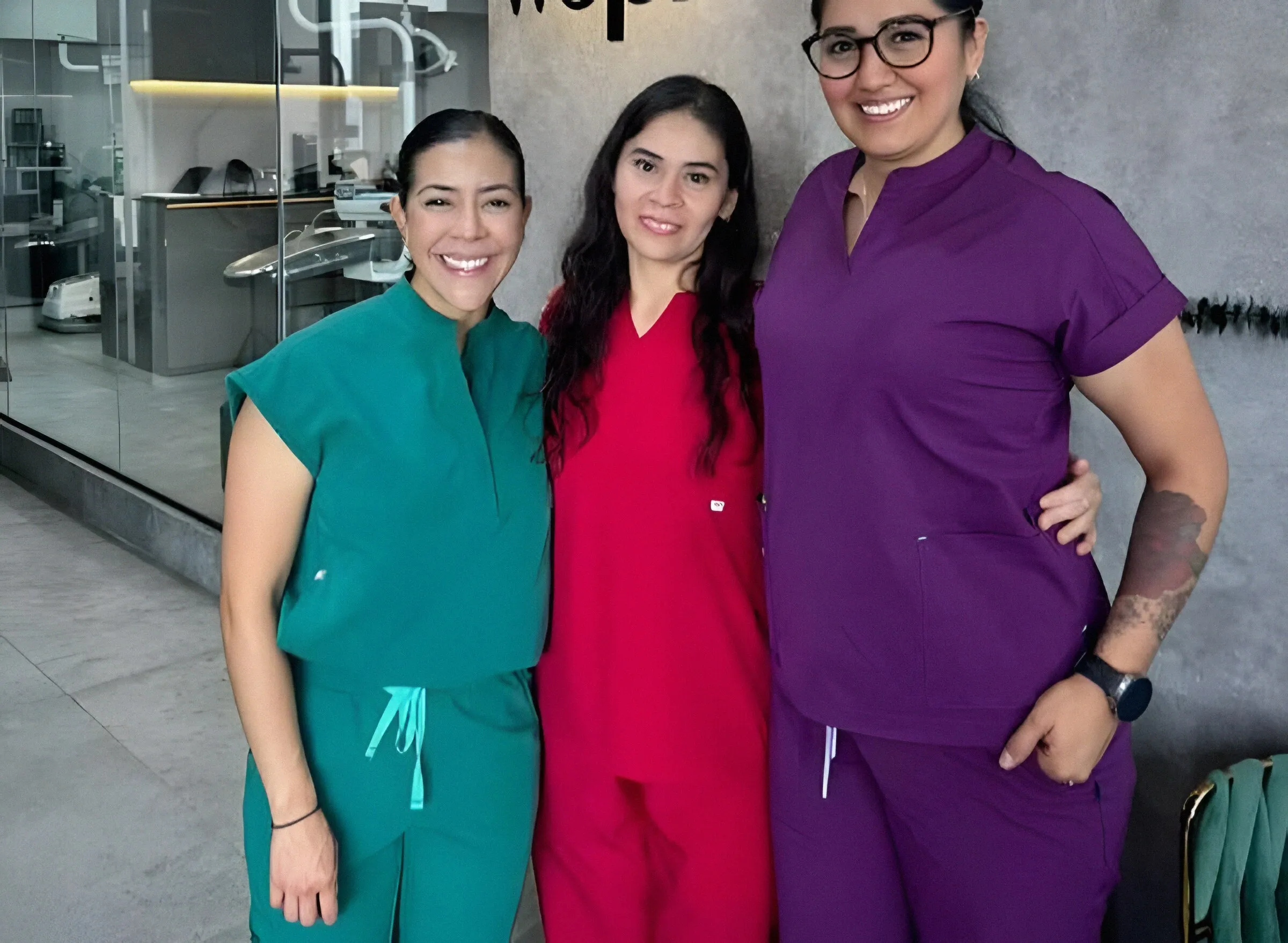 Tres integrantes del equipo de Wepro con uniformes verde, rojo y morado